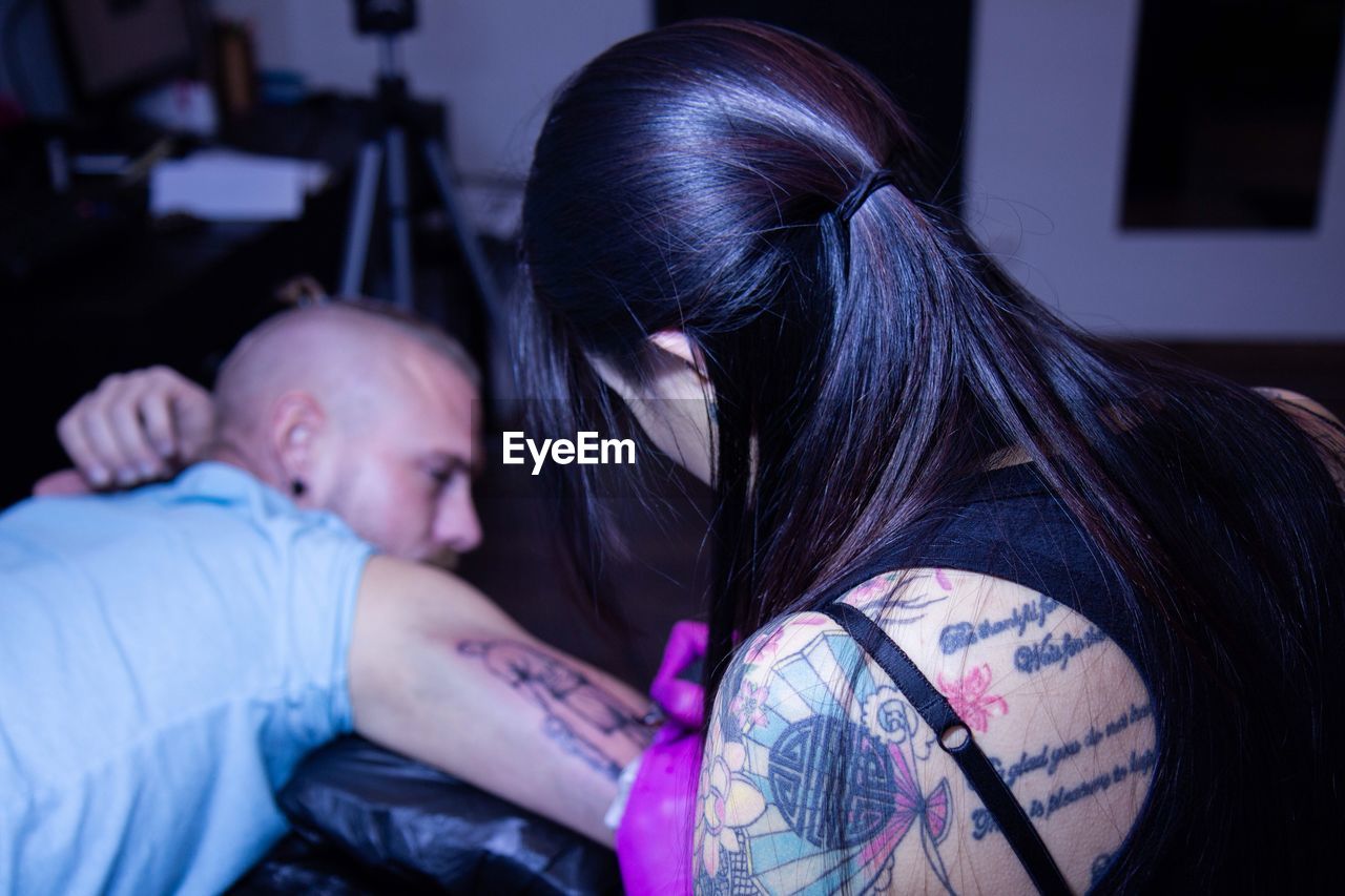 Close-up of tattoo artist tattooing man