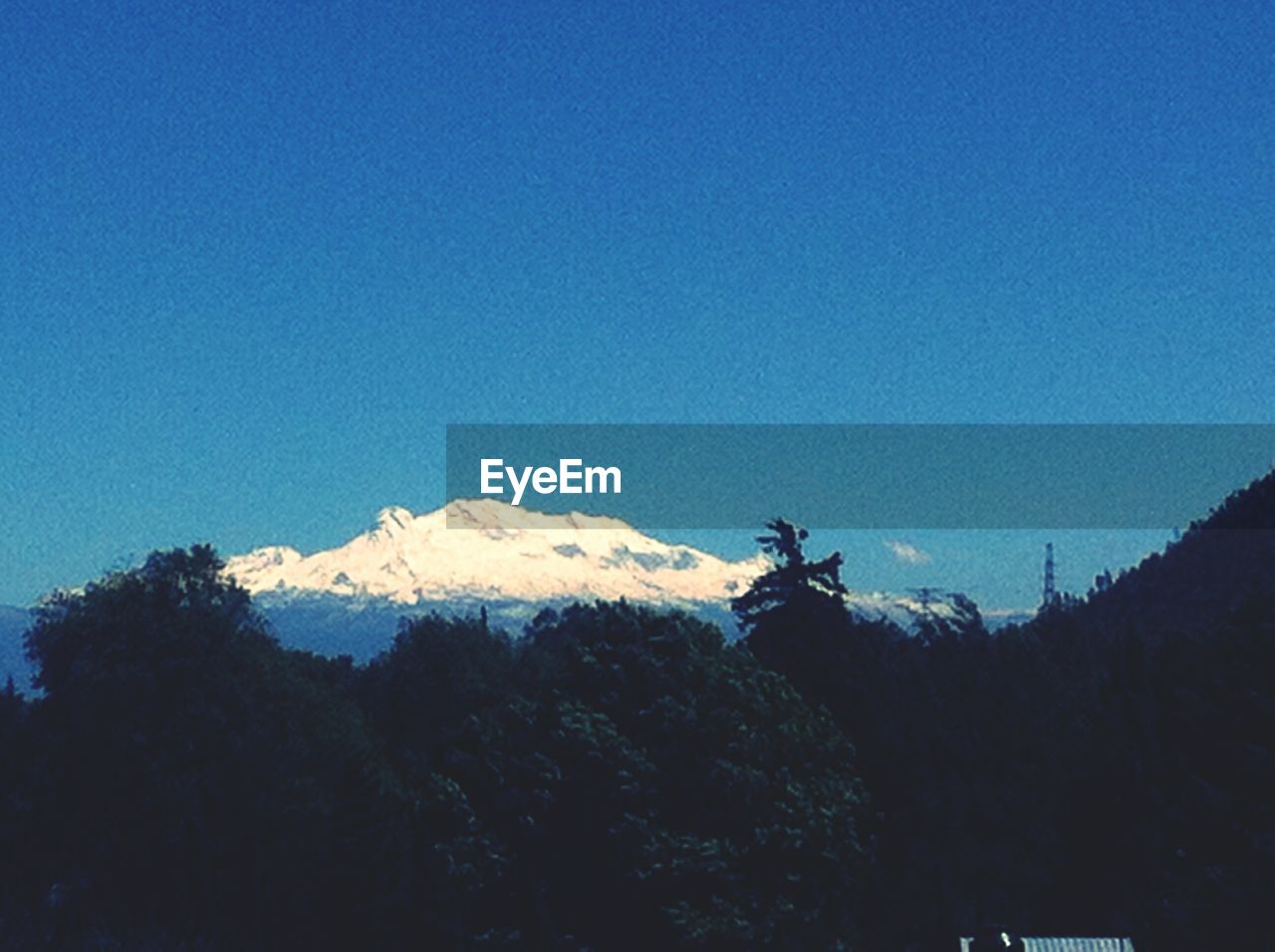 LOW ANGLE VIEW OF SILHOUETTE MOUNTAIN AGAINST BLUE SKY