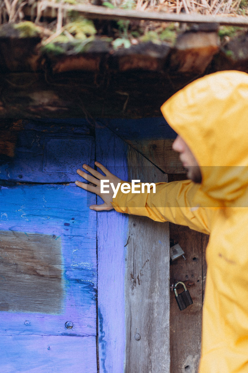 MIDSECTION OF WOMAN HOLDING YELLOW UMBRELLA