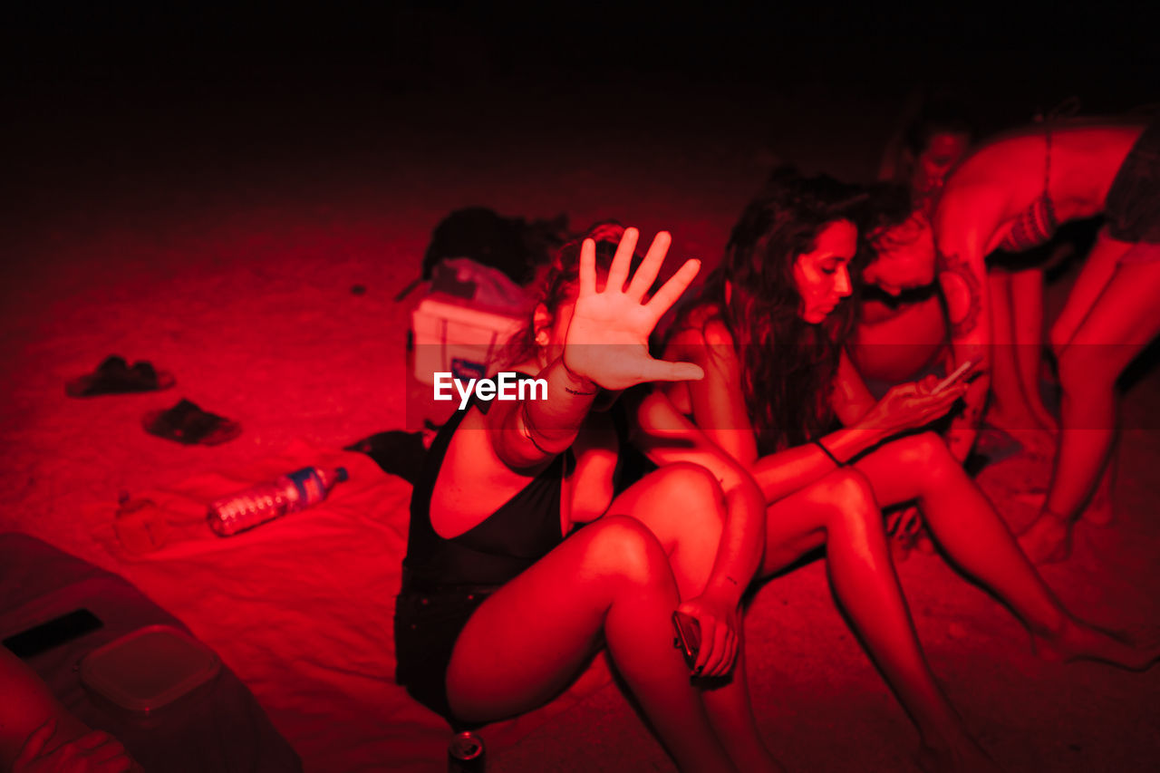 High angle view of women sitting on sand outdoors at night