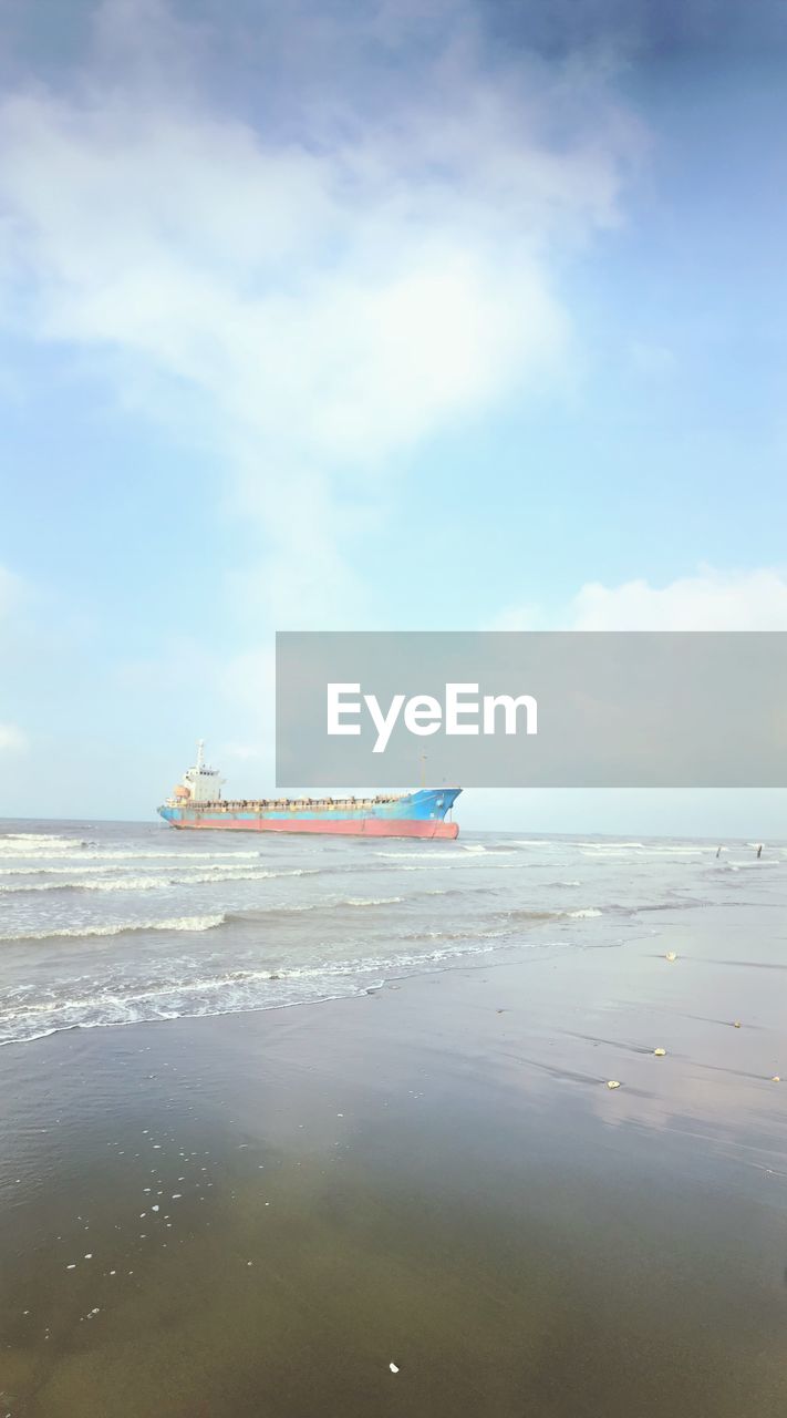 BOAT ON BEACH AGAINST SKY