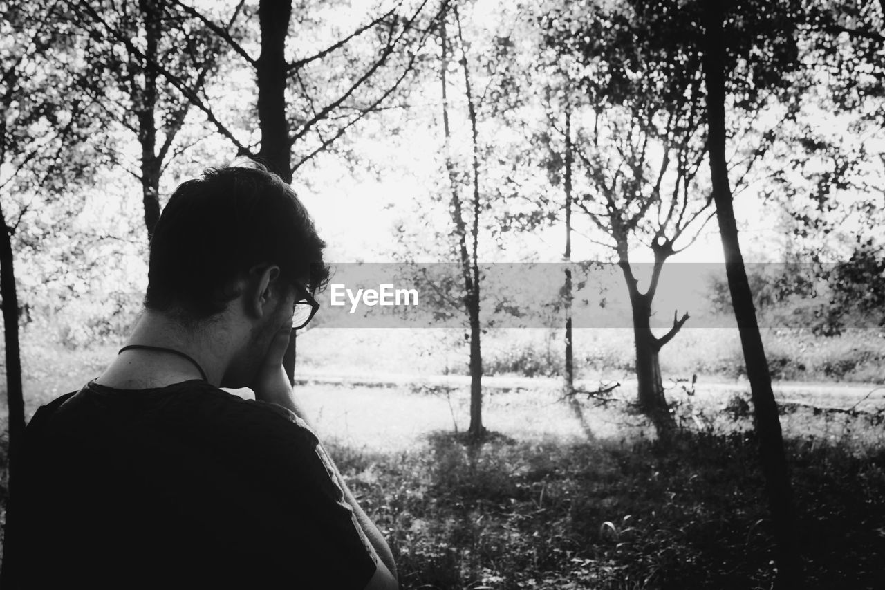 MAN LOOKING AT FOREST