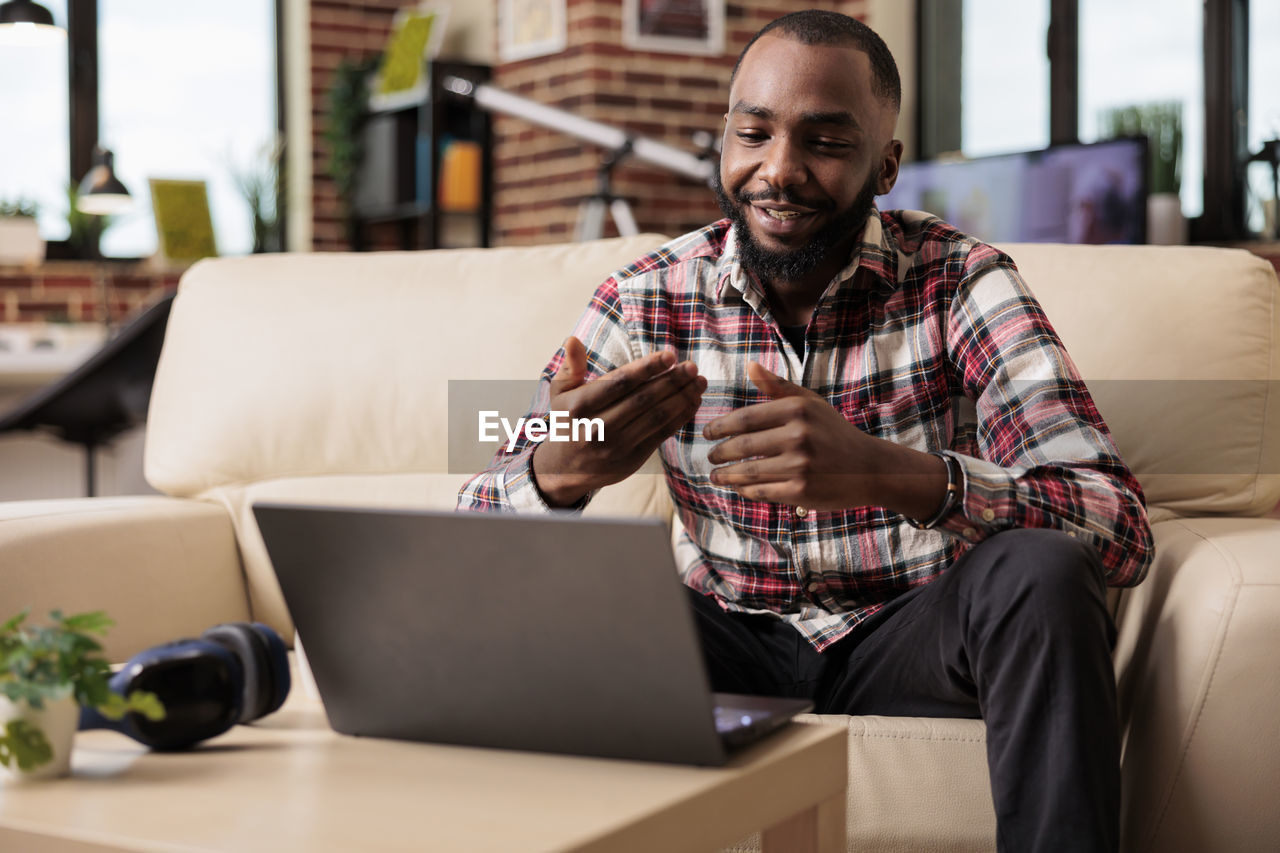 portrait of young man using digital tablet while sitting on table