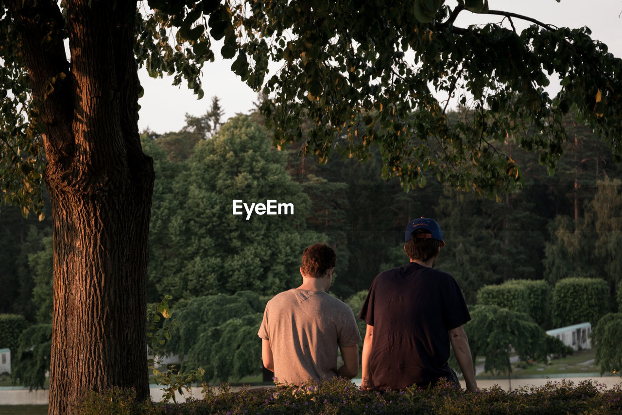 Rear view of friends relaxing in park