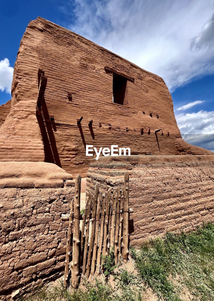 rock, sky, landscape, ruins, nature, land, ancient history, architecture, travel destinations, cloud, scenics - nature, environment, history, desert, travel, non-urban scene, no people, the past, geology, built structure, beauty in nature, ancient, outdoors, arch, monument, rural scene, rock formation, tourism, valley, mountain, day, tranquility, tranquil scene, grass, sunlight, plant, building exterior, climate, building, extreme terrain, old ruin, archaeological site, remote, temple, semi-arid