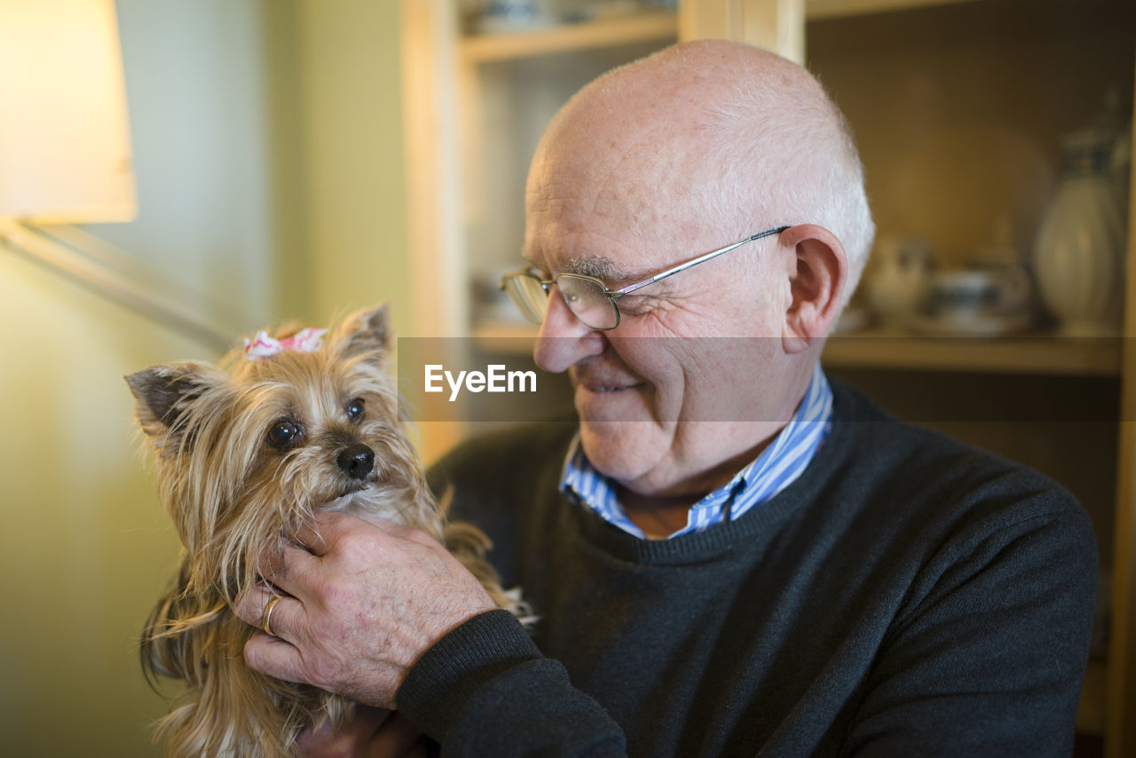 Senior man with his yorkshire terrier at home