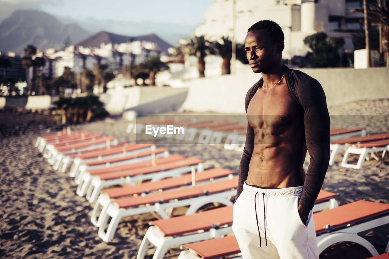 Muscular man standing at beach