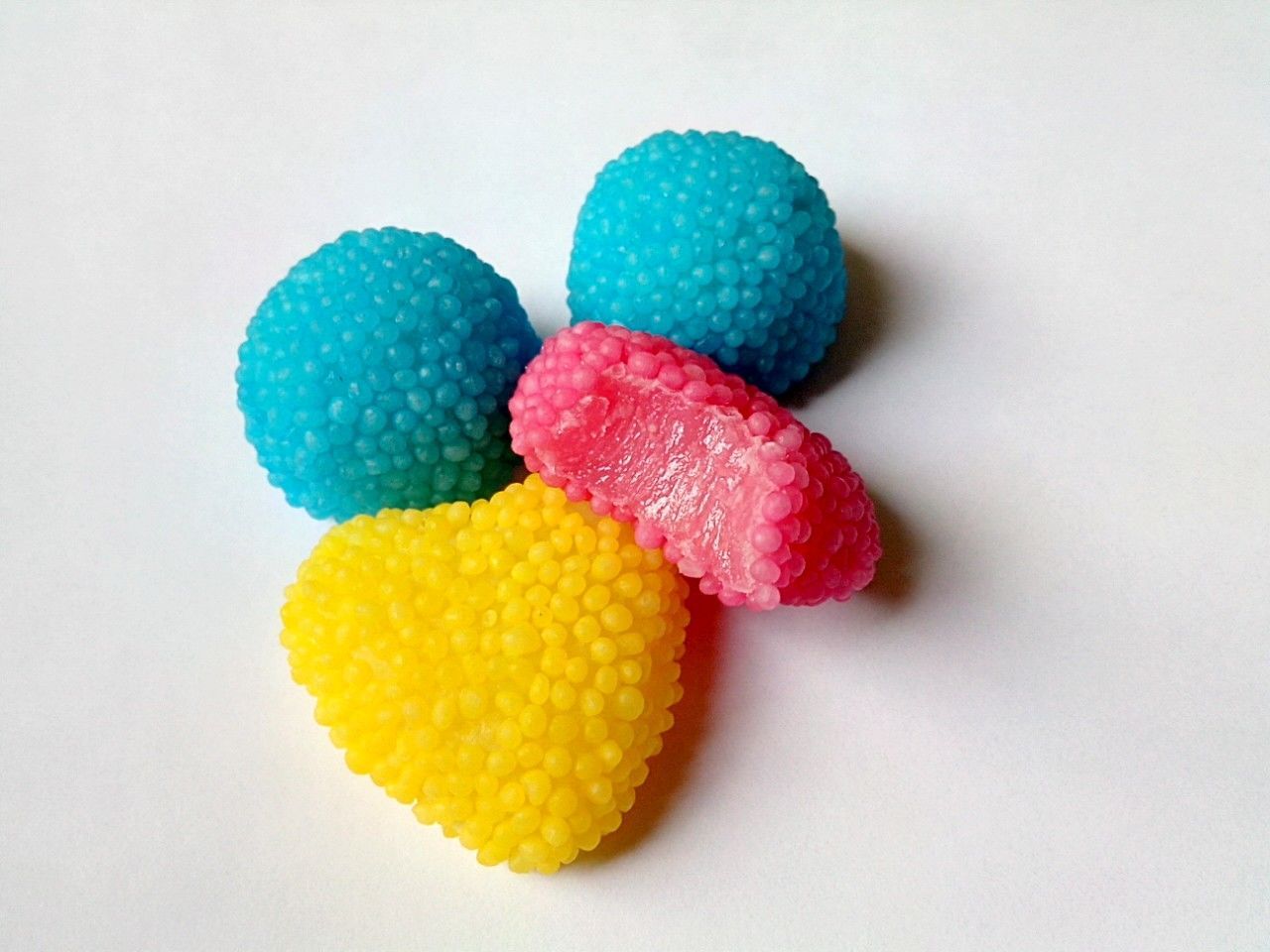 Close-up of multi colored sweet balls against white background