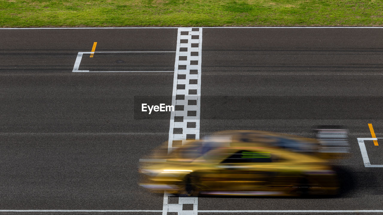 Race car blurred motion crossing the finish line on international circuit speed track, motion blur.