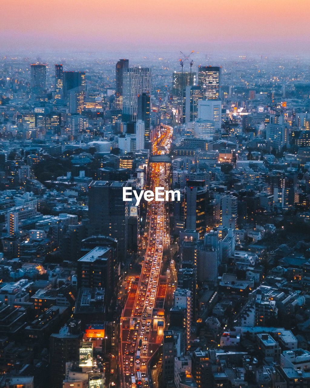 High angle view of illuminated cityscape against sky at dusk