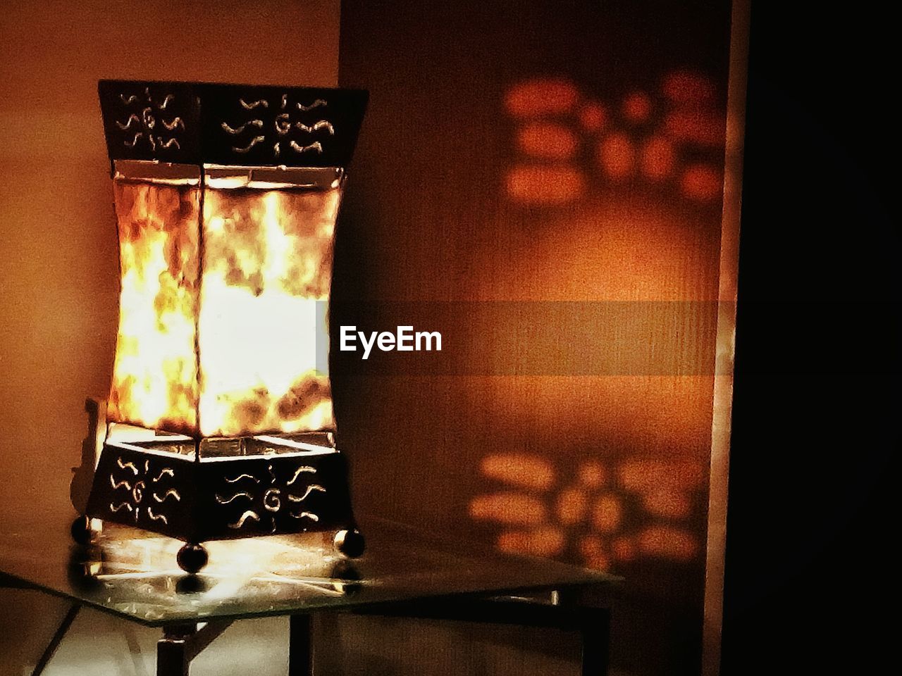 CLOSE-UP OF ILLUMINATED CANDLES ON TABLE