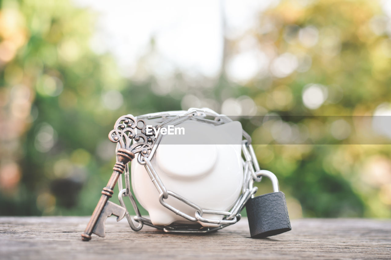 Close-up of piggy bank with key and lock on table