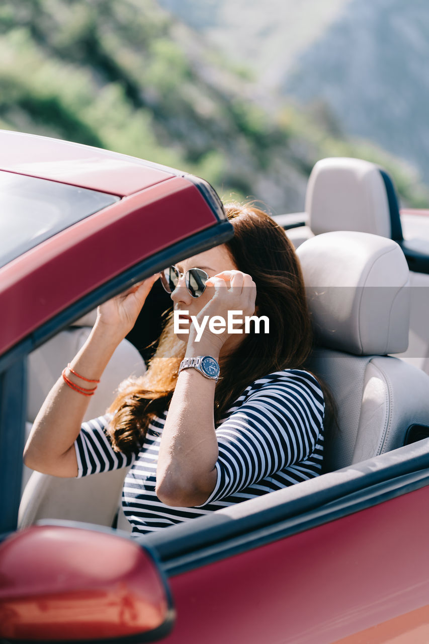 Woman wearing sunglasses sitting in car