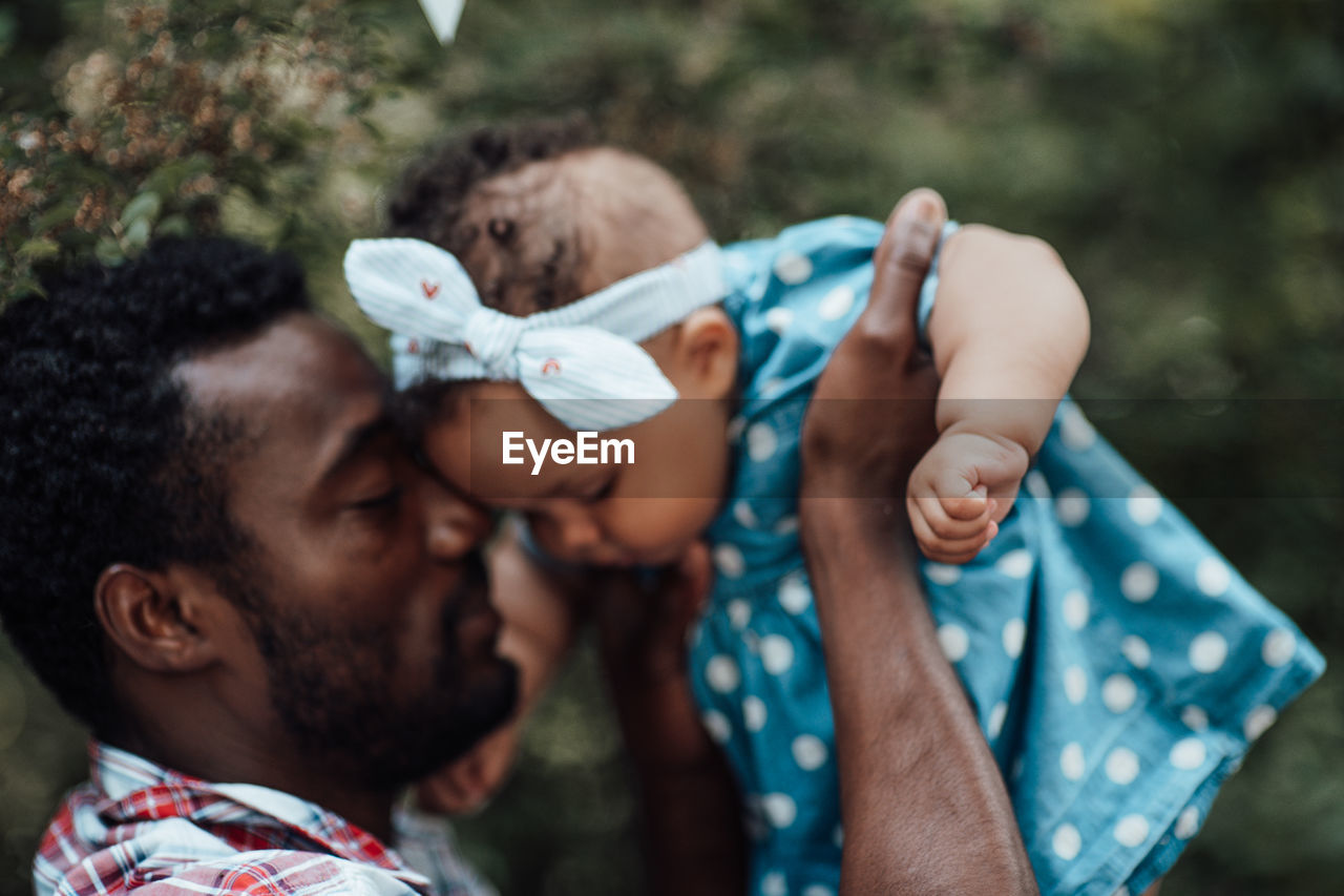 Father holding daughter outdoors