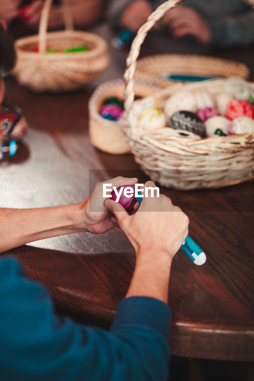 Cropped hands of woman cutting easter egg