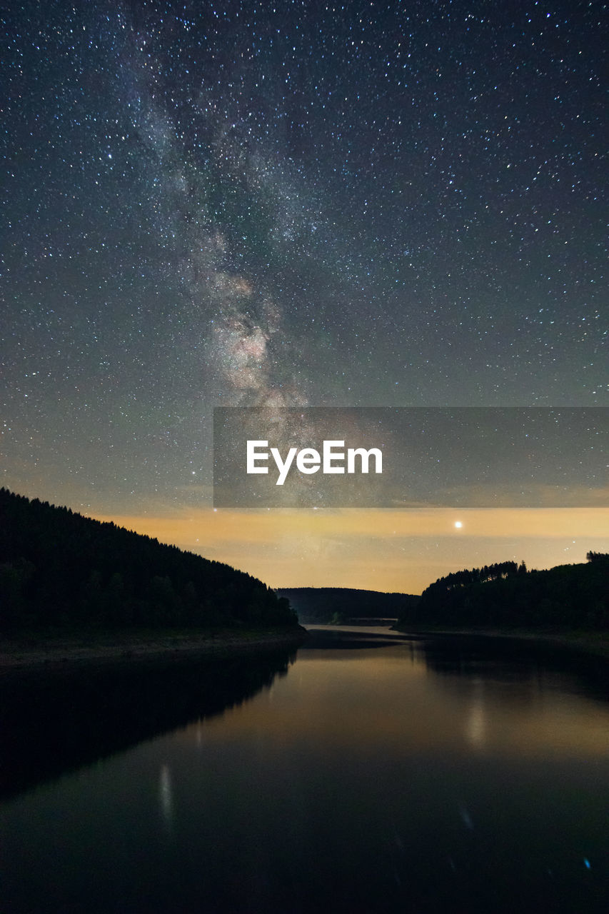 Scenic view of lake against sky at night