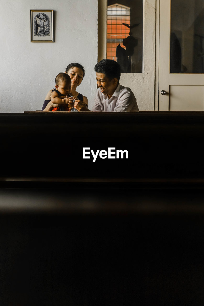 GROUP OF PEOPLE SITTING ON TABLE WITH TEXT