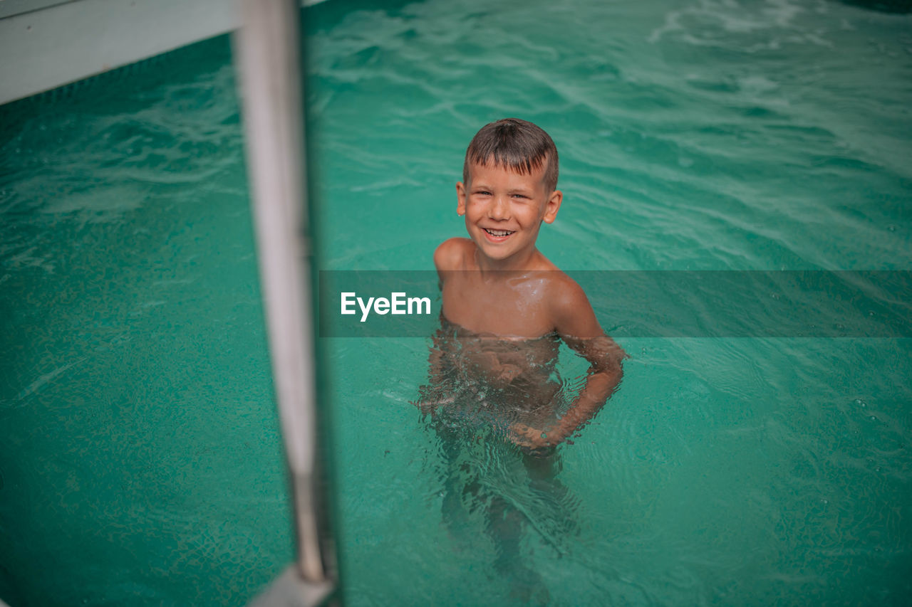 Portrait of shirtless boy in swimming pool