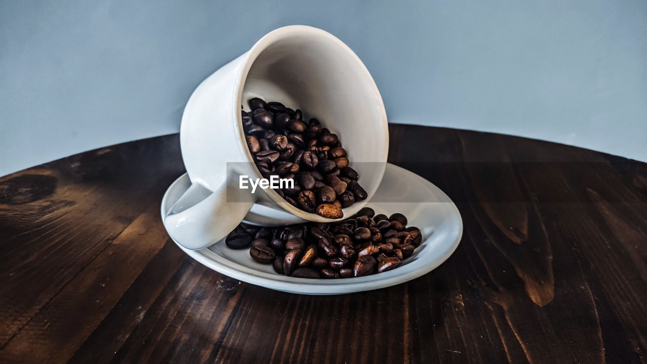 HIGH ANGLE VIEW OF COFFEE BEANS IN CUP ON TABLE