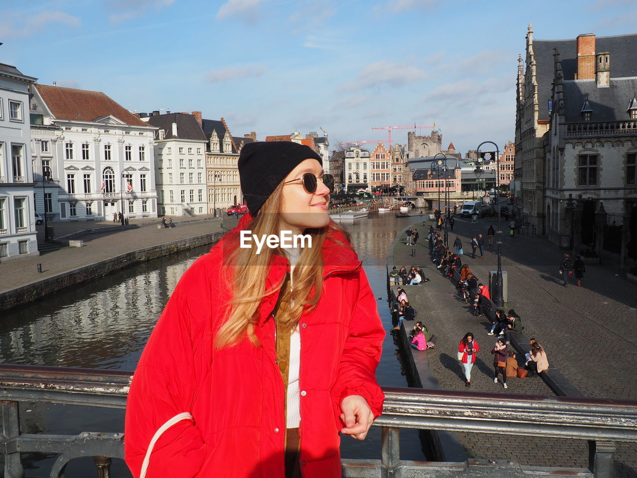 Woman standing by railing in city