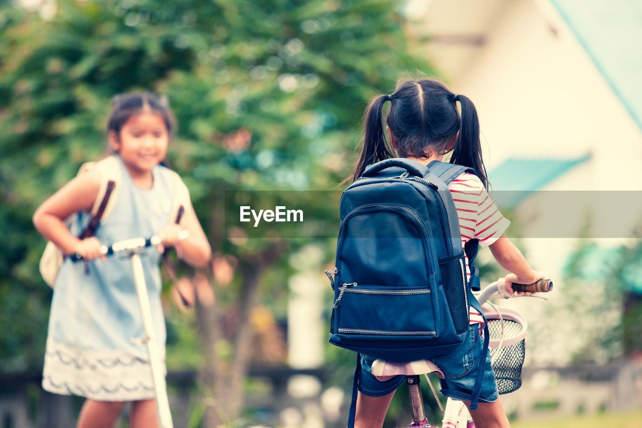 Rear view of schoolgirl riding bicycle