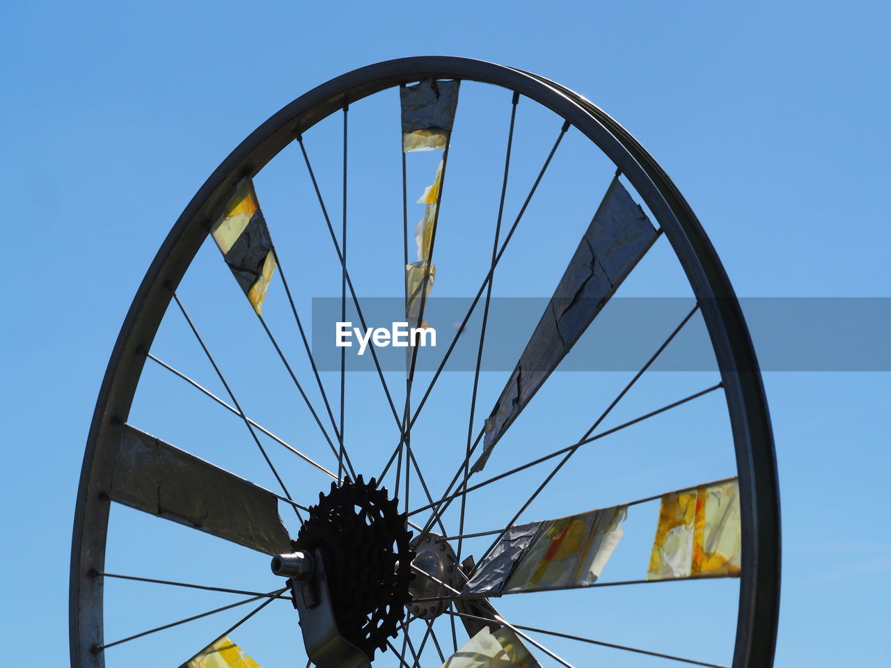 Low angle view of wheel against clear blue sky