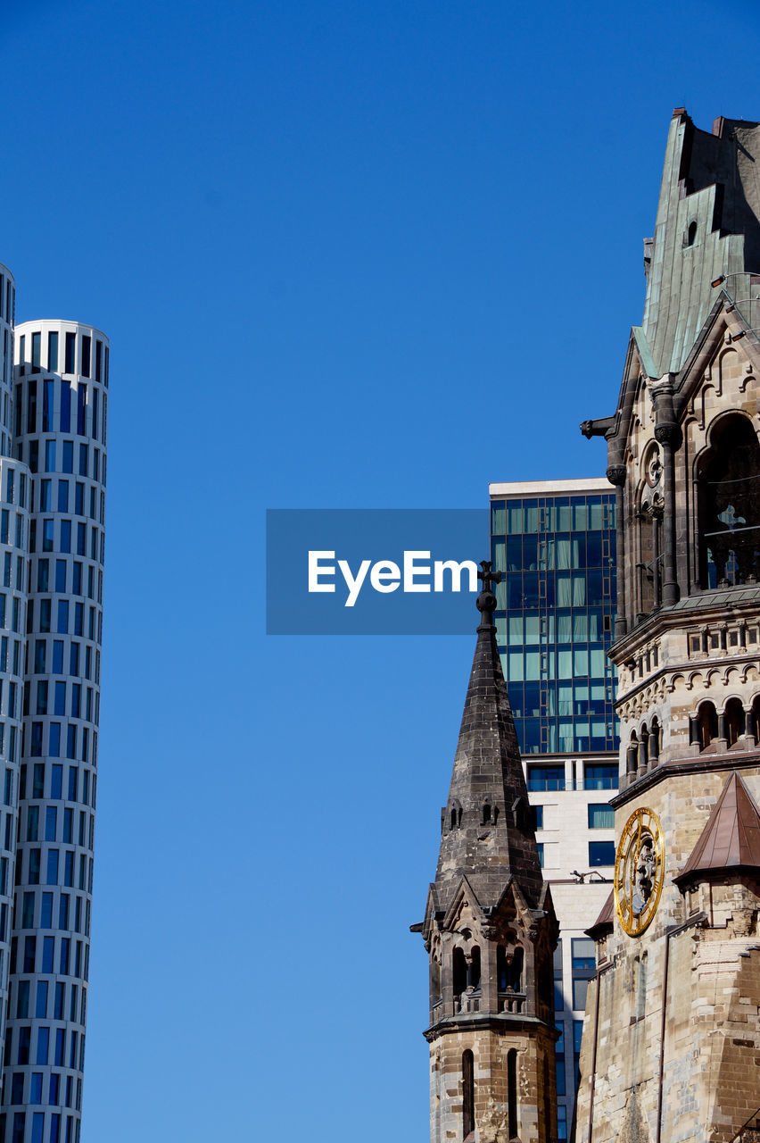 Low angle view of kaiser wilhelm memorial church in city against clear blue sky