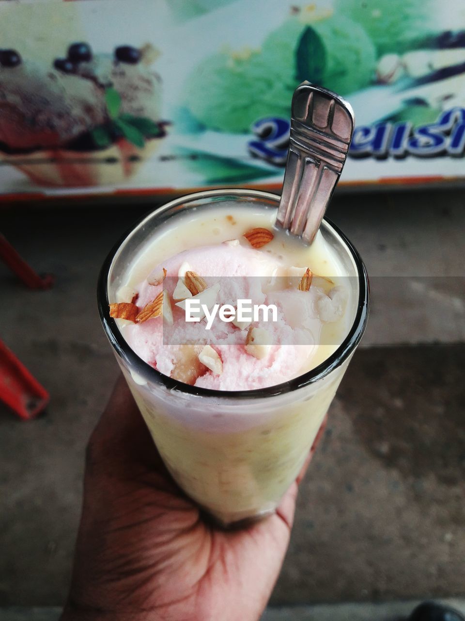 CLOSE-UP OF HAND HOLDING ICE CREAM CONE IN GLASS