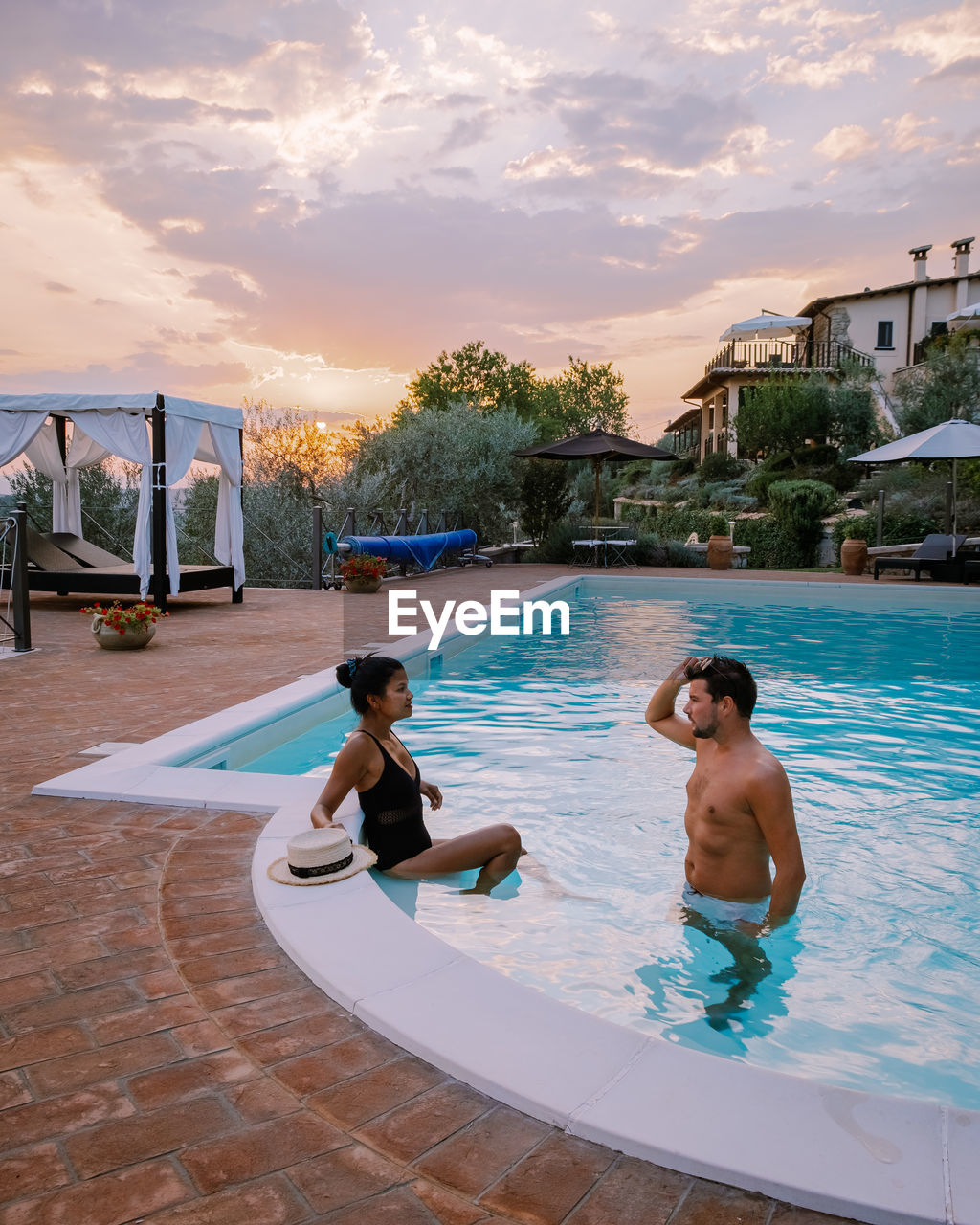 Men in swimming pool against sky