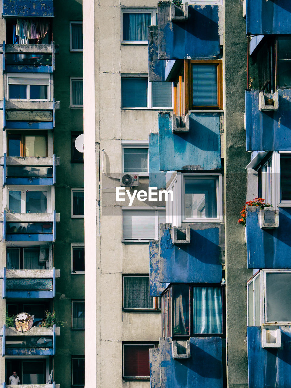 Crowded old balconies in run-down project housing with one man in sarajevo 