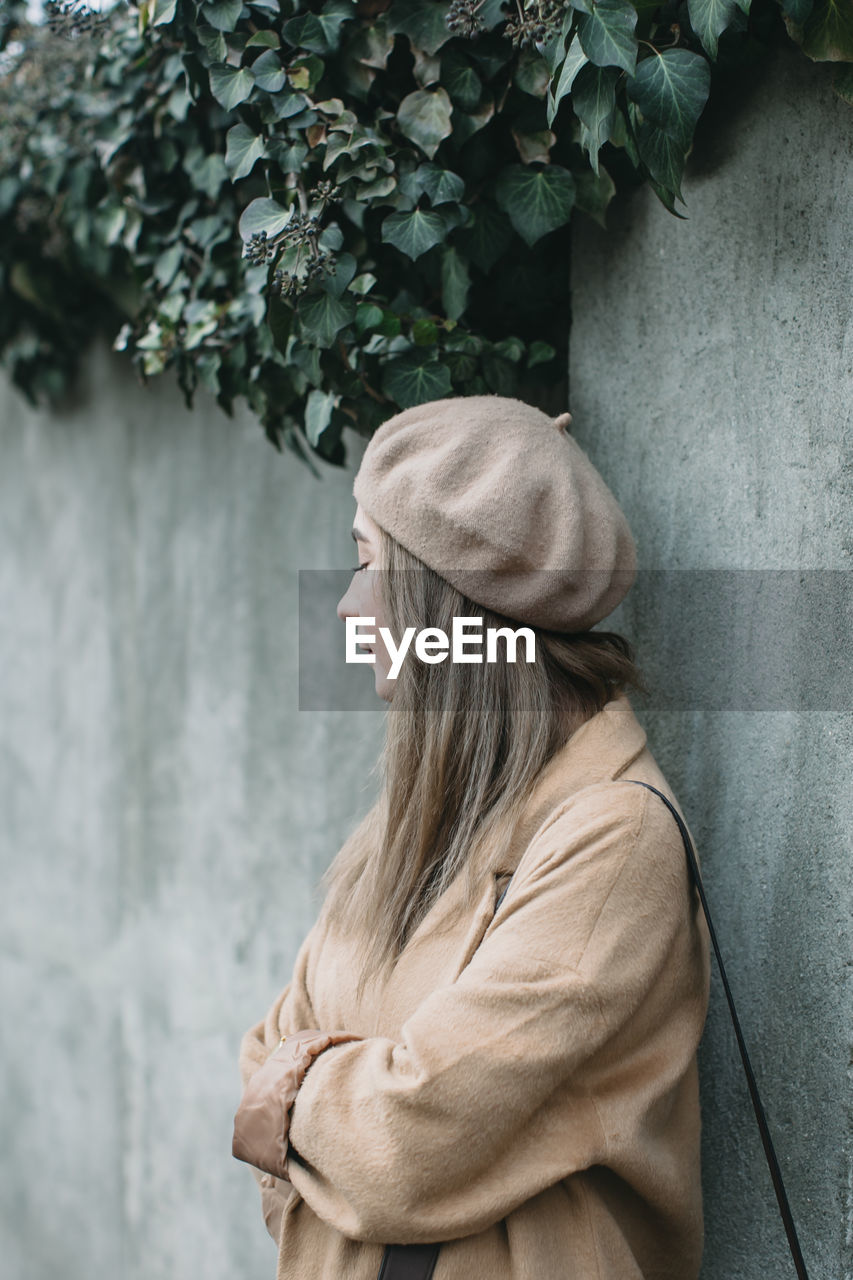 Woman standing by wall