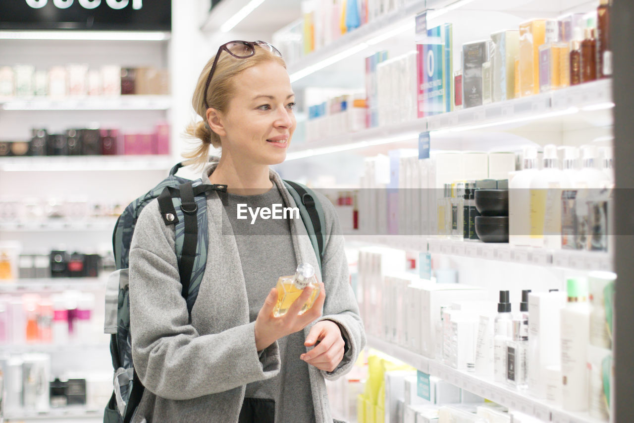 Smiling woman standing in front of store