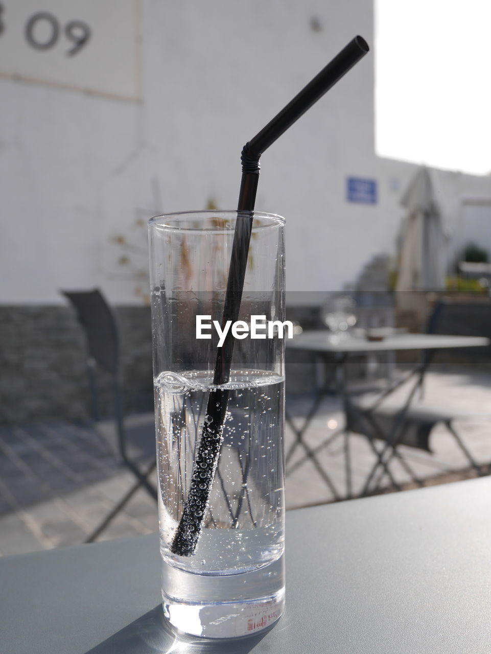 Close-up of carbonated water with drinking straw in glass on table