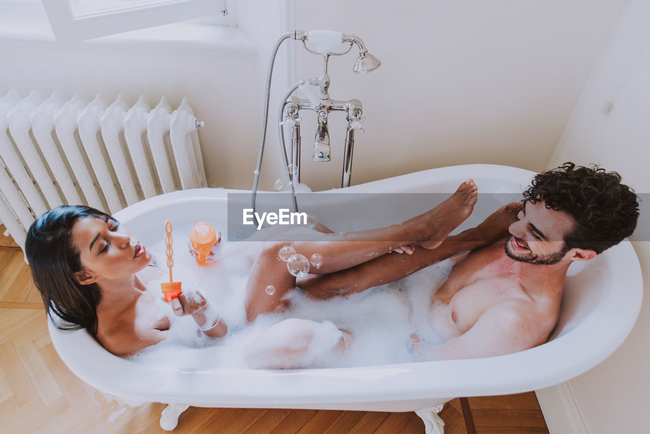 High angle view of couple sitting in bathtub