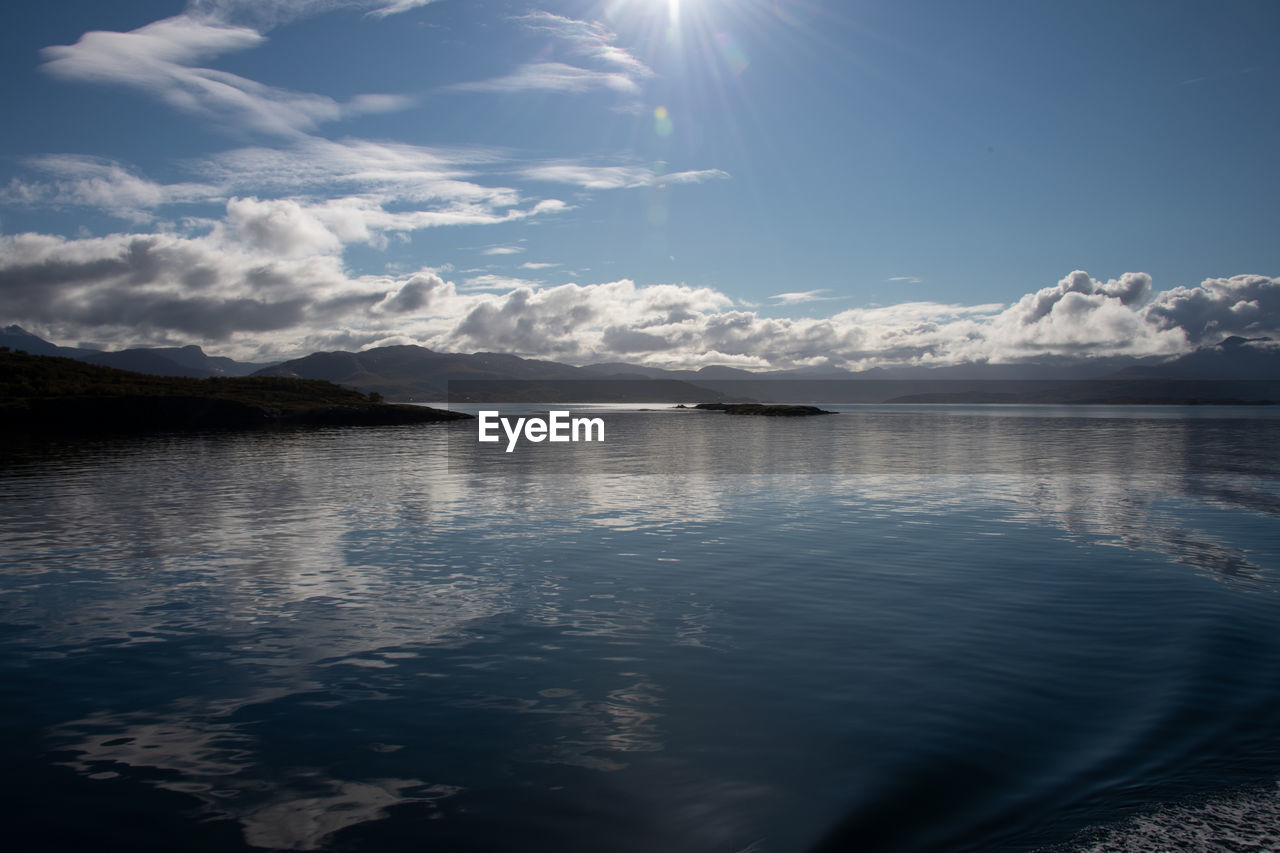 reflection, water, sky, cloud, horizon, scenics - nature, beauty in nature, sunlight, nature, mountain, sea, tranquility, ocean, environment, tranquil scene, no people, dusk, landscape, sunbeam, blue, outdoors, day, light, mountain range, sun, travel, travel destinations, wave, land, snow, cold temperature, moonlight, body of water, idyllic, ice, morning, non-urban scene