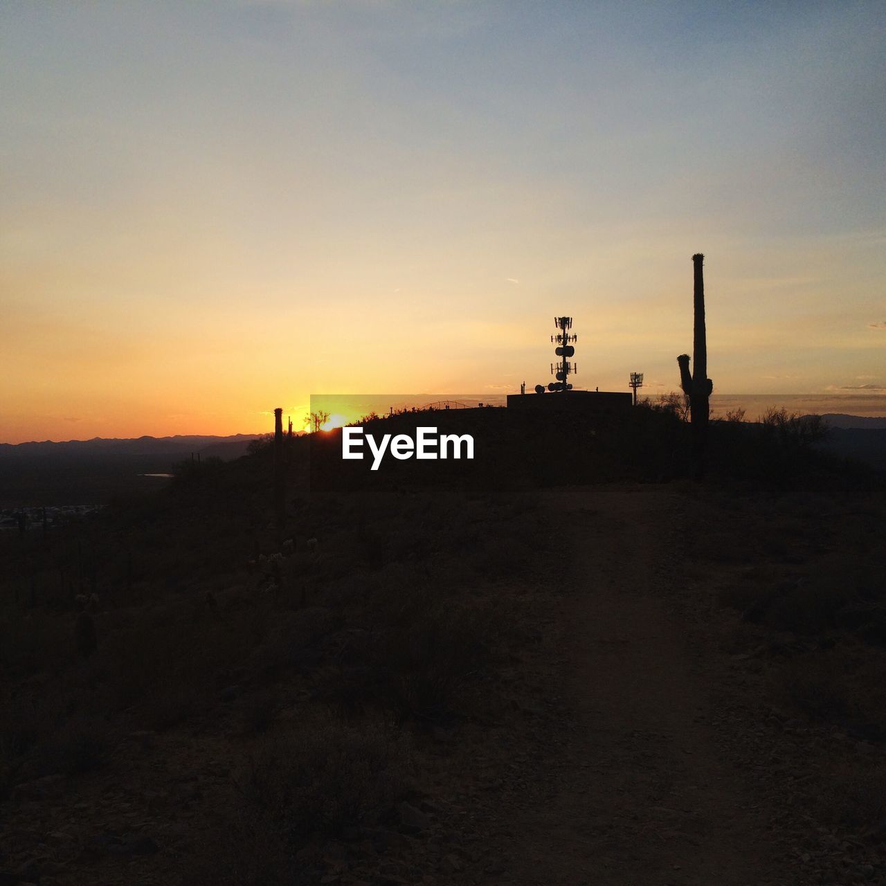 SILHOUETTE OF FACTORY ON FIELD AGAINST SKY