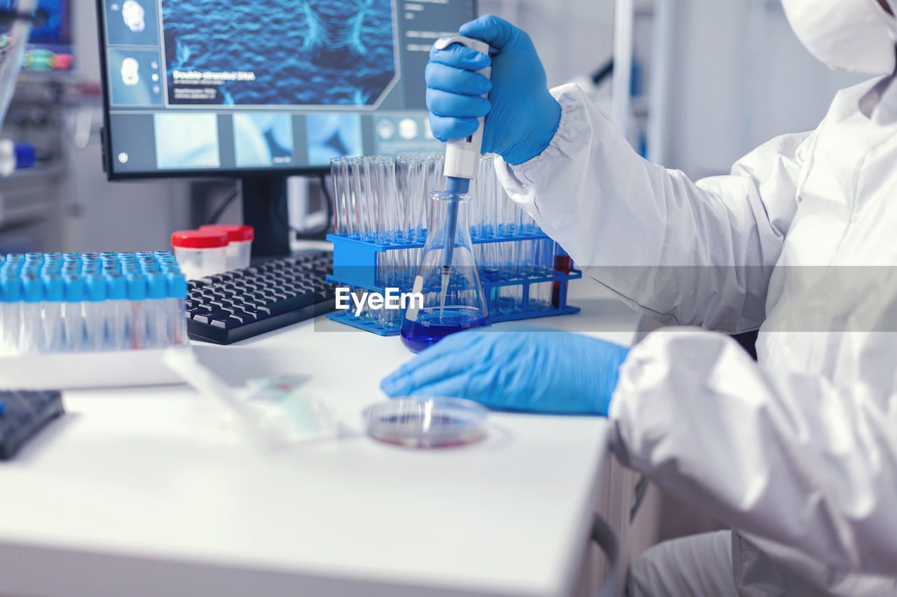 midsection of scientist working on table