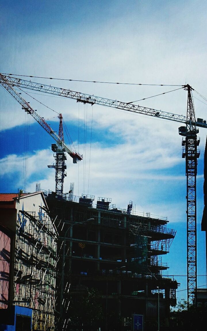 LOW ANGLE VIEW OF CRANE AND CRANE AGAINST SKY