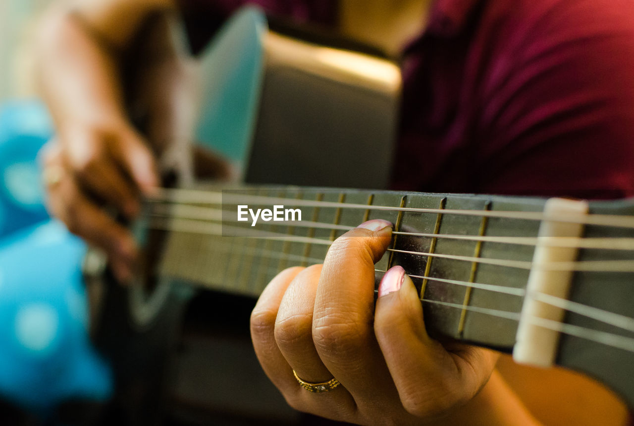 Cropped image of woman playing guitar