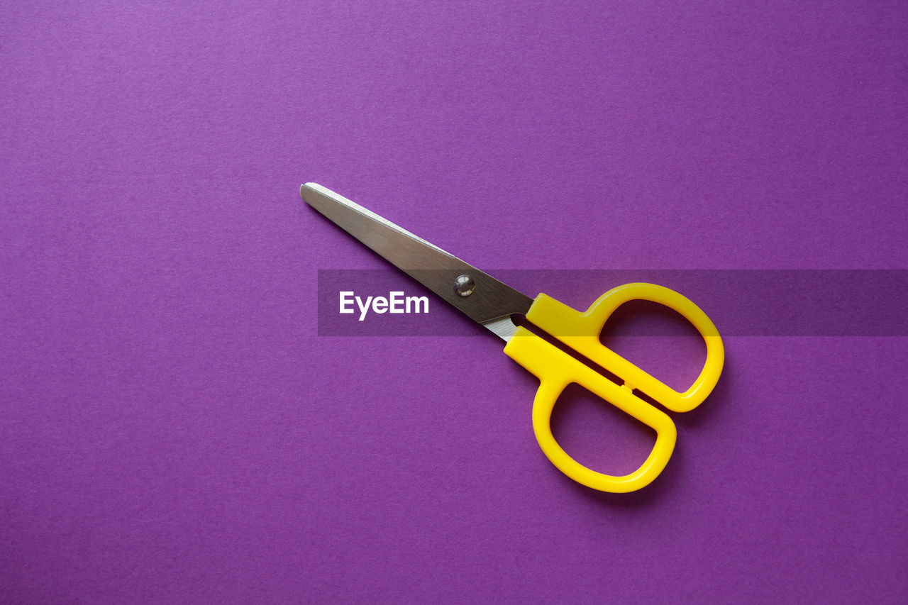 Scissor on purple background