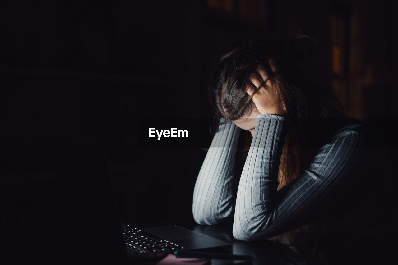 side view of young woman using mobile phone while sitting at home