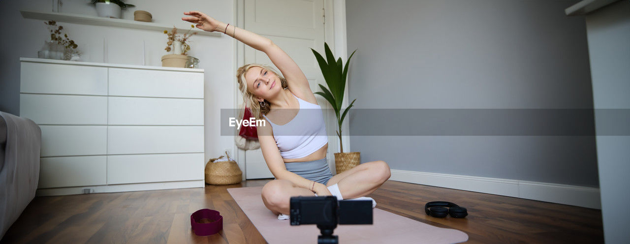 low section of woman exercising on floor at home