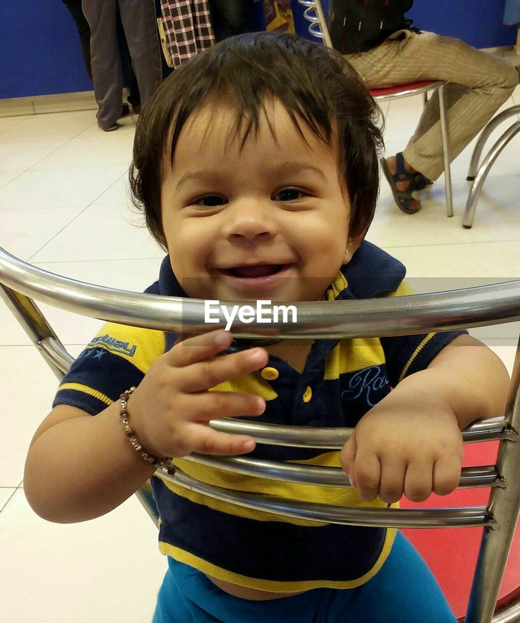 PORTRAIT OF CUTE BOY SITTING ON SMILING