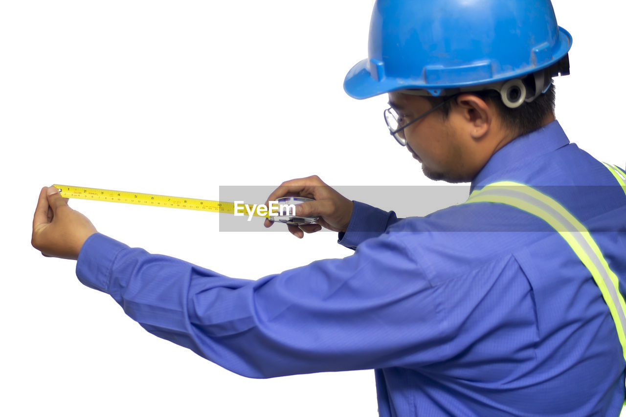MAN WORKING AGAINST BLUE SKY