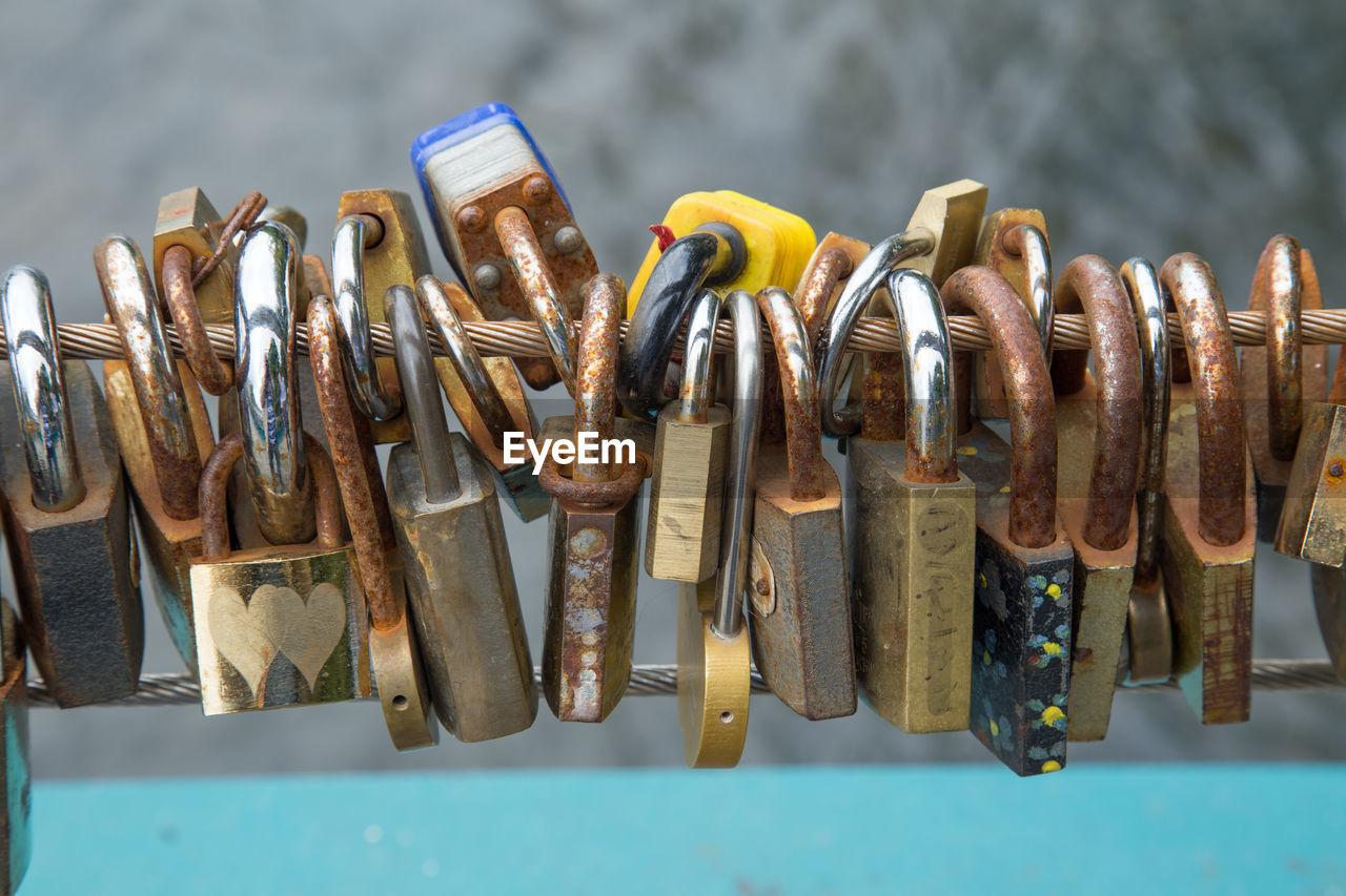 CLOSE-UP OF PADLOCKS HANGING ON METAL CHAIN