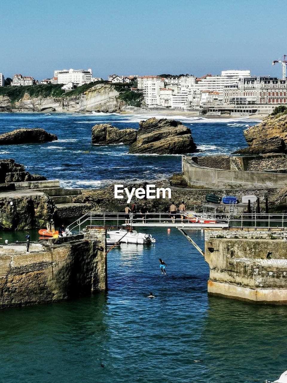 SCENIC VIEW OF SEA AGAINST BUILDINGS IN CITY