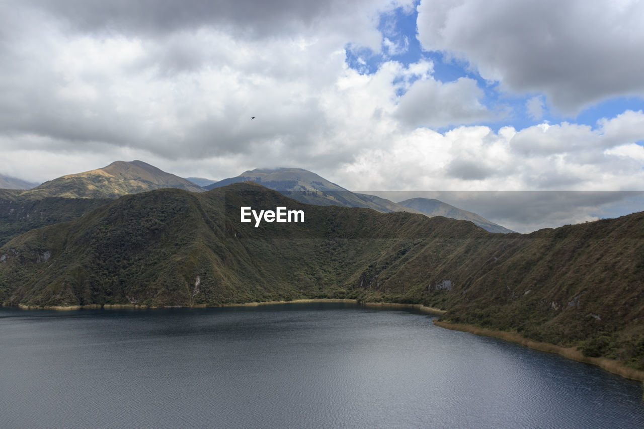 Scenic view of lake by mountains against sky