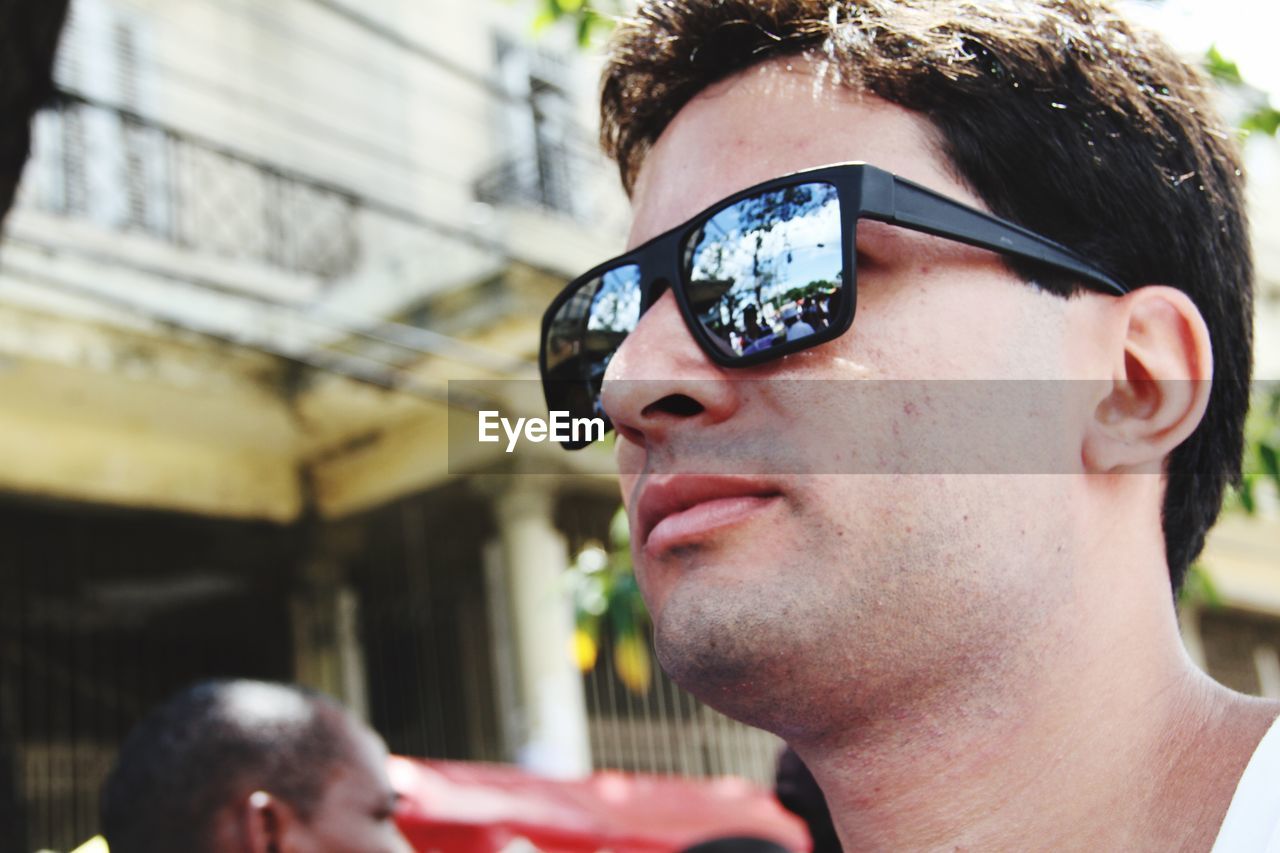 PORTRAIT OF YOUNG MAN WEARING SUNGLASSES