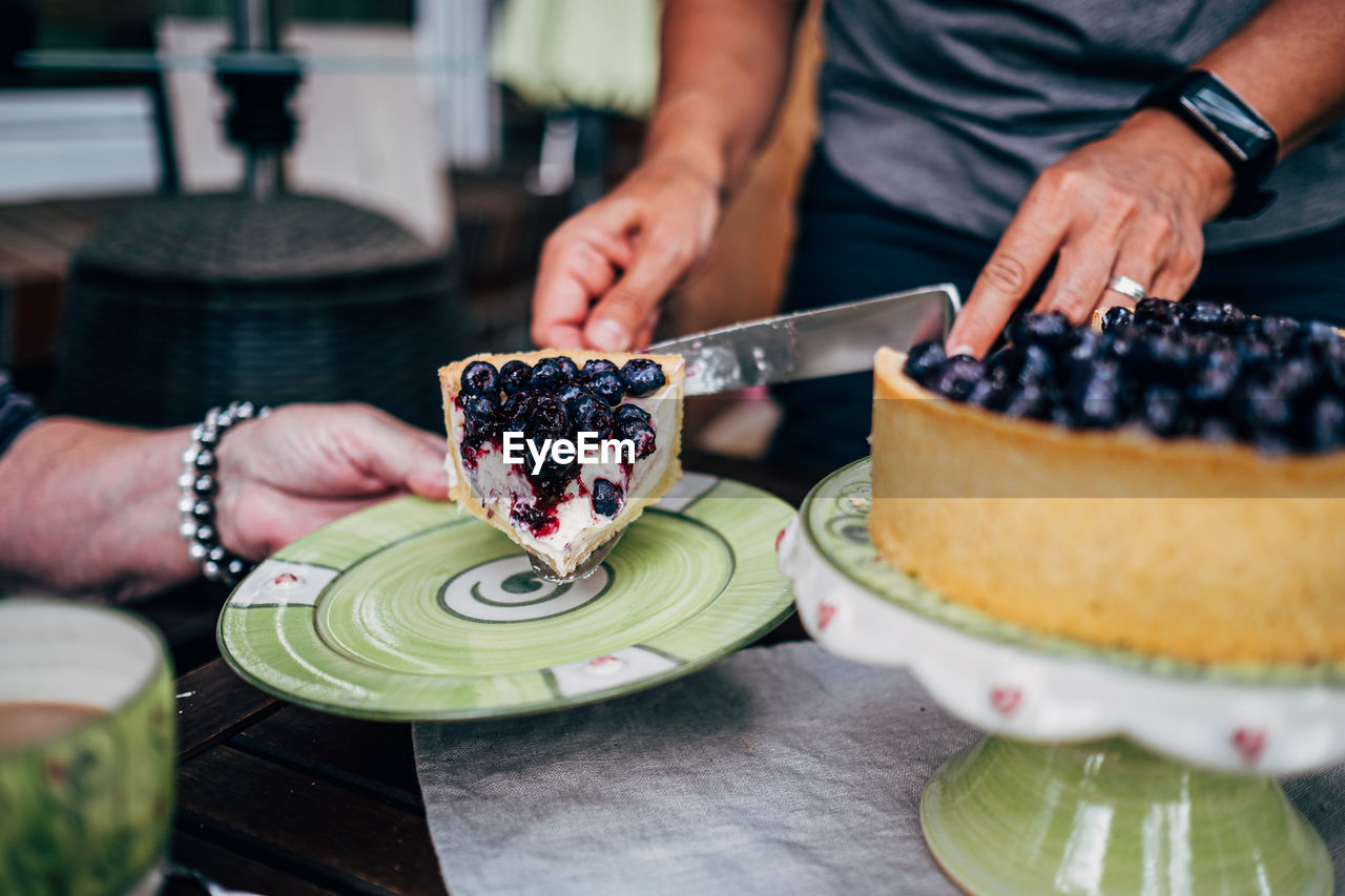 Midsection of woman preparing cake on table