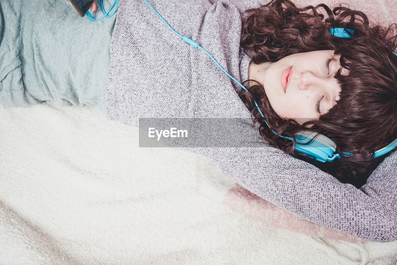 High angle view of woman listening music at home